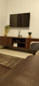 a living room with a flat screen tv on a entertainment center at Oceanic Unit 99 - North Beach in Durban