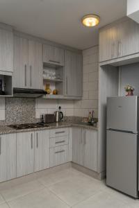 a kitchen with wooden cabinets and a white refrigerator at Oceanic Unit 99 - North Beach in Durban