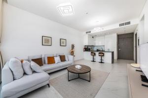 a living room with two couches and a table at Aesthetic 1Br Chrystal Lagoon in Dubai