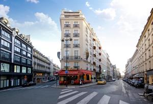 ein hohes weißes Gebäude in einer Stadtstraße in der Unterkunft Hotel Opéra Richepanse in Paris