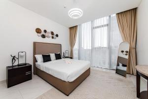 a bedroom with a bed and a large window at Aesthetic 1Br Chrystal Lagoon in Dubai +9 photos