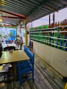 a restaurant with tables and chairs and a wall with vases at Dream Vision Guest House in Diu