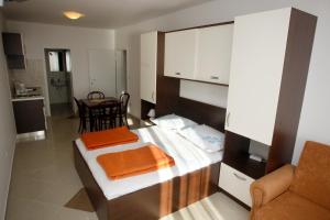 a small room with a bed and a kitchen at Apartments Rubic in Omiš +23 photos