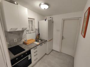 a kitchen with white cabinets and a refrigerator at Tonino House in Pag +24 photos