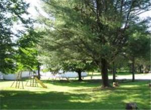 un parque con un parque infantil con árboles y un tobogán en Four Seasons Motel, en Catskill