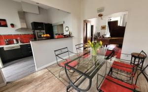 a living room with a glass table and a kitchen at Gîte de charme Sinfonia in Bergerac