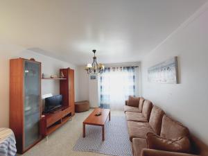 a living room with a couch and a tv at GreenSea II in Peniche +2 photos