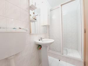a white bathroom with a sink and a shower at GreenSea II in Peniche