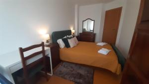 a small bedroom with a bed and a mirror at GreenSea II in Peniche