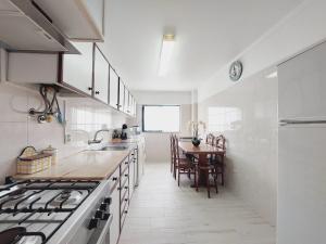 a kitchen with a table and a stove top oven at GreenSea II in Peniche