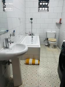 a bathroom with a sink and a tub and a toilet at Spacious and comfortable House in Kampala Uganda in Kasiyirize
