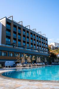 a hotel with a swimming pool with chairs and umbrellas at Sile Gonen Hotel in Şile