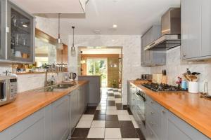 cocina grande con encimeras de madera y electrodomésticos de acero inoxidable en Scandi inspired holiday home Brentwood, en Brentwood 24 fotos más