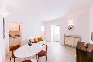 un soggiorno bianco con tavolo e sedie bianchi di Casa Don Matteo a Scala
