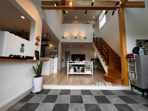 a living room with a staircase and a checkered floor at Goldcoast IKI B&B in Iki