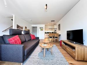 a living room with a couch and a tv at Staufner Maisonette in Oberstaufen
