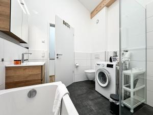 a white bathroom with a washing machine in it at Staufner Maisonette in Oberstaufen +5 photos