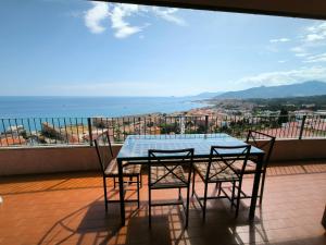 a table and chairs on a balcony with a view of the ocean at Panorama - By Ligooria in Pietra Ligure +6 photos