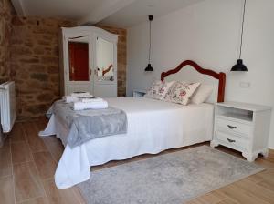 a bedroom with a large white bed and a mirror at El Legado de Acha in Cambados