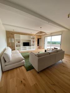 ein großes Wohnzimmer mit Sofa und TV in der Unterkunft Domaine du Puy Doré in Sainte-Cécile