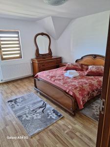 a bedroom with a bed and a dresser and a window at Cabana iris- dotata cu ciubar si sauna in Agapia