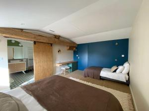 ein Schlafzimmer mit zwei Betten und einer blauen Wand in der Unterkunft Domaine du Puy Doré in Sainte-Cécile + 20 Fotos