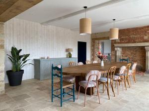 ein Esszimmer mit einem großen Holztisch und Stühlen in der Unterkunft Domaine du Puy Doré in Sainte-Cécile