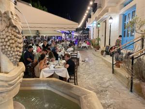 eine Gruppe von Menschen, die nachts in einem Restaurant sitzen in der Unterkunft Villa Kallista in Pissouri