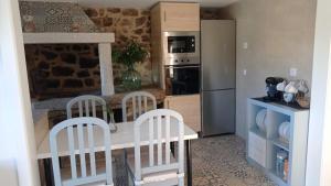 a kitchen with a counter with chairs and a refrigerator at El Legado de Acha in Cambados
