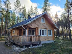 a log cabin in the woods with a porch at Camping Hossan Lumo in Hossa