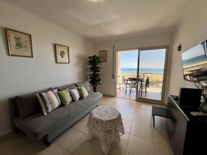 a living room with a couch and a table at Monte Gordo Beach Ocean View 3 by Homing in Monte Gordo