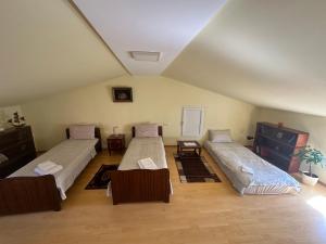 una stanza con tre letti e sedie di Green ToniC Hostel a Kutaisi
