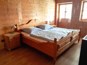 a bed in a room with a wooden wall at Untere Firstalm in Schliersee
