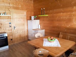 a wooden kitchen with a wooden table with a bowl of fruit at Untere Firstalm in Schliersee