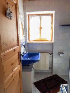 a bathroom with a blue sink and a window at Untere Firstalm in Schliersee