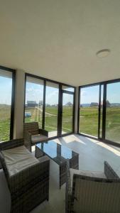 une chambre avec des chaises, une table et des fenêtres dans l'établissement Apartman BUKOVAC, à Žabljak