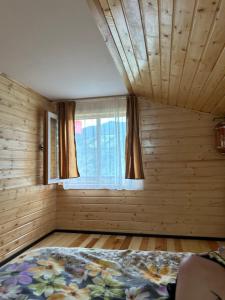 una camera da letto con un letto e una finestra di Panoramic Escape a Broşteni