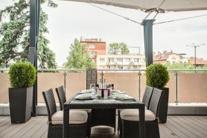 y balcón con mesa de comedor y sillas. en Hemus Hotel Sofia en Sofía