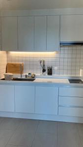 una cucina con mobili bianchi e un lavandino di Seha Stay a Suncheon