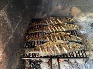 a group of fish cooking on a grill at My Mediterranean Villa with Huge Garden and own Parking in Lumbarda