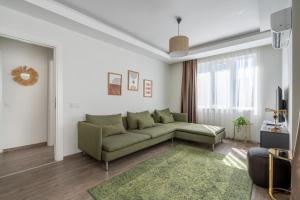 a living room with a green couch and a window at Sorta Hotel in Antalya
