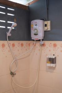 um chuveiro na casa de banho com uma mangueira ligada à parede em Serene Escape in Pai em Ban Wiang Nua