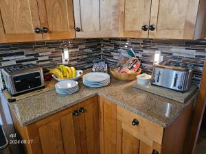 a kitchen counter with a bowl of bananas and a microwave at Small Town Bound Inn in Montague +26 photos
