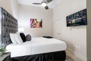 a bedroom with a large white bed with a headboard at Tasteful Condo Walking Distance to French Quarter in New Orleans +21 photos