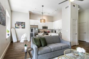 a living room with a couch and a kitchen at Tasteful Condo Walking Distance to French Quarter in New Orleans