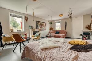 a bedroom with a bed and a living room at Appartement YCW 'Papillon' in Rijnsaterwoude