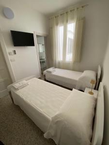 ガラティーナにあるA Casa di Ninaのベッド2台と薄型テレビ付きのホテルの部屋