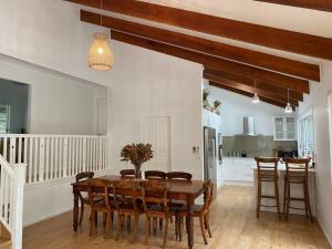 a kitchen and dining room with a wooden table and chairs at Peppertree in Smiths Lake