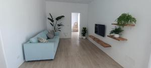 a living room with a blue couch and some plants at Casa Bincoblanco, balcony of the Atlantic in Guía de Isora