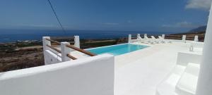 a swimming pool on the side of a white house at Casa Bincoblanco, balcony of the Atlantic in Guía de Isora